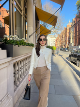 a lady in a beige stand collar jacket with camel pants